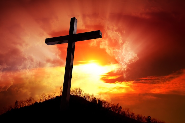 Silhouette of a cross at sunset — a symbol of faith, not proof everything happens for a reason