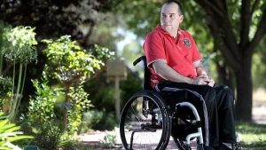 John Duthie, author of Alive and Not Kicking, sitting in his wheelchair outdoors after his spinal cord injury