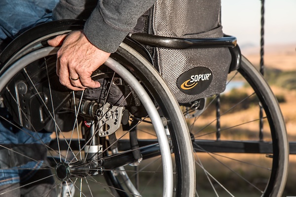 Close-up of a manual wheelchair wheel and brake, representing daily life with spinal cord injury